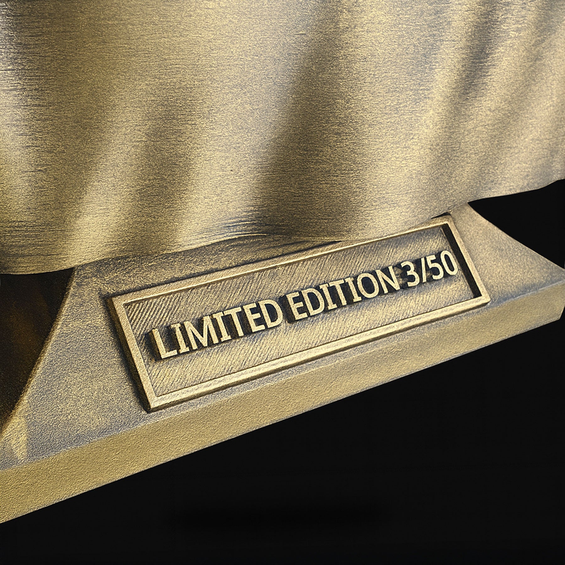 Charlie Kirk bust gold nameplate close-up — engraved plaque reflective finish